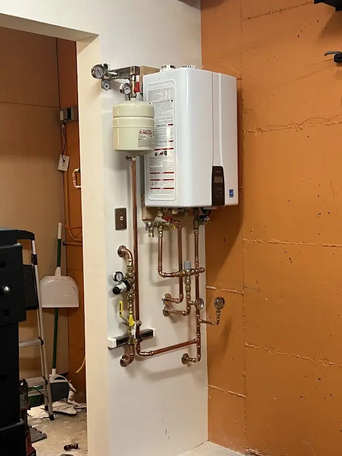 Plumbing technician inspecting water heater connections in La Salle